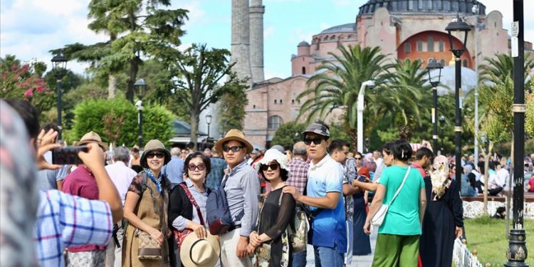 Tourists take photo in front of historical Hagia Sophia.