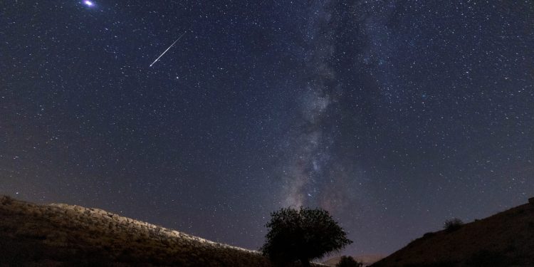 A meteor streaks past stars in the night sky during the annual Perseid meteor shower.