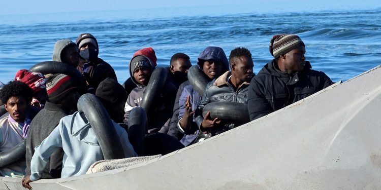 Migrants are pictured on a metal boat as Tunisian coastguards try to stop them at sea during their attempt to cross to Italy, off Sfax, Tunisia, April 27, 2023. (Reuters photo)